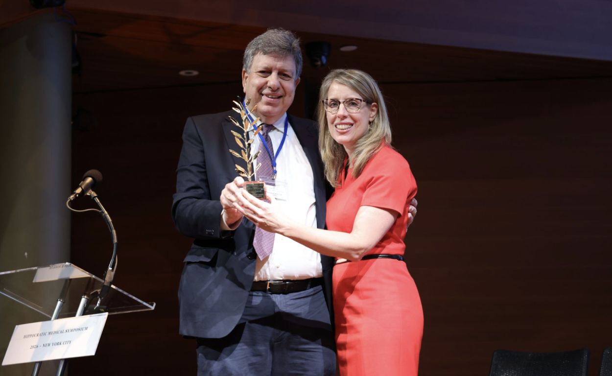 A Symposium honoree receives the golden laurel.